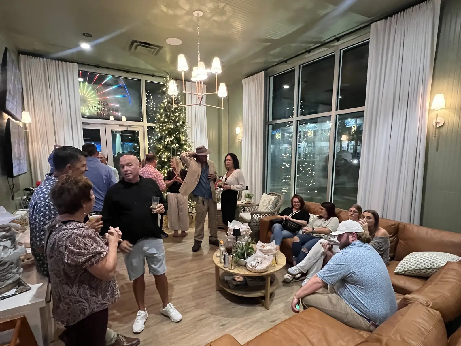 The lounge at Tee Off at The Wharf — leather sofas and high tables filled with a private group